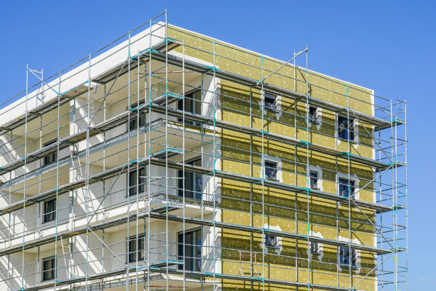 Pose de panneaux isolants sur la façade d'une maison en rénovation.